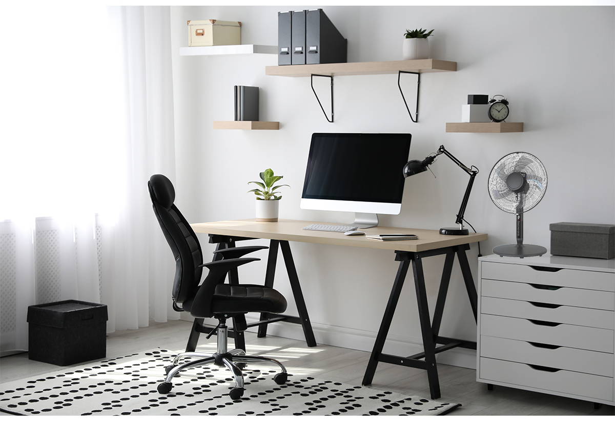 Απεικονίζεται ένα δωμάτιο με γραφείο, καρέκλα και συρταριέρα στην οποία είναι τοποθετημένος ο επιτραπέζιος ανεμιστήρας .